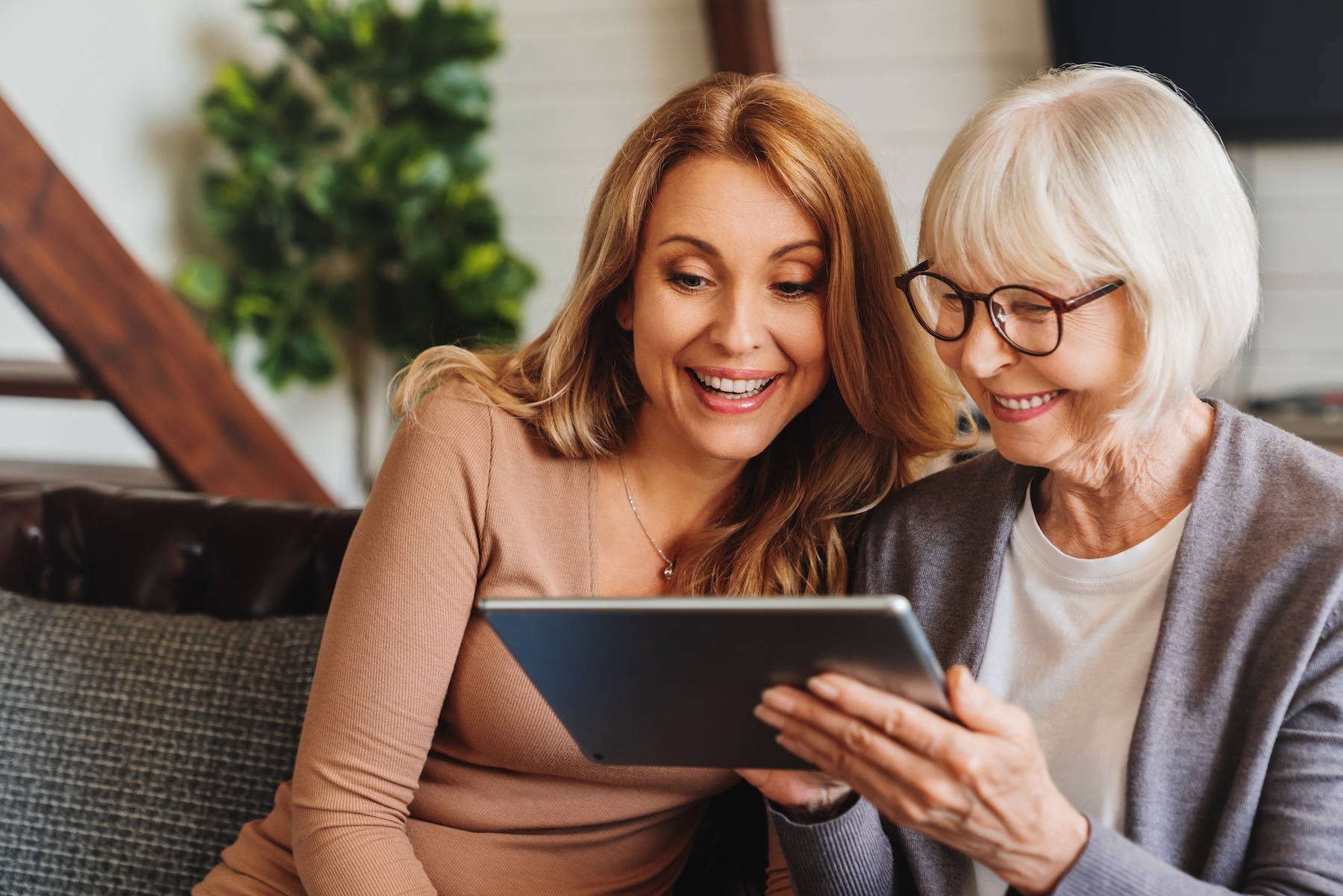 Senior woman and her daughter using tablet at home